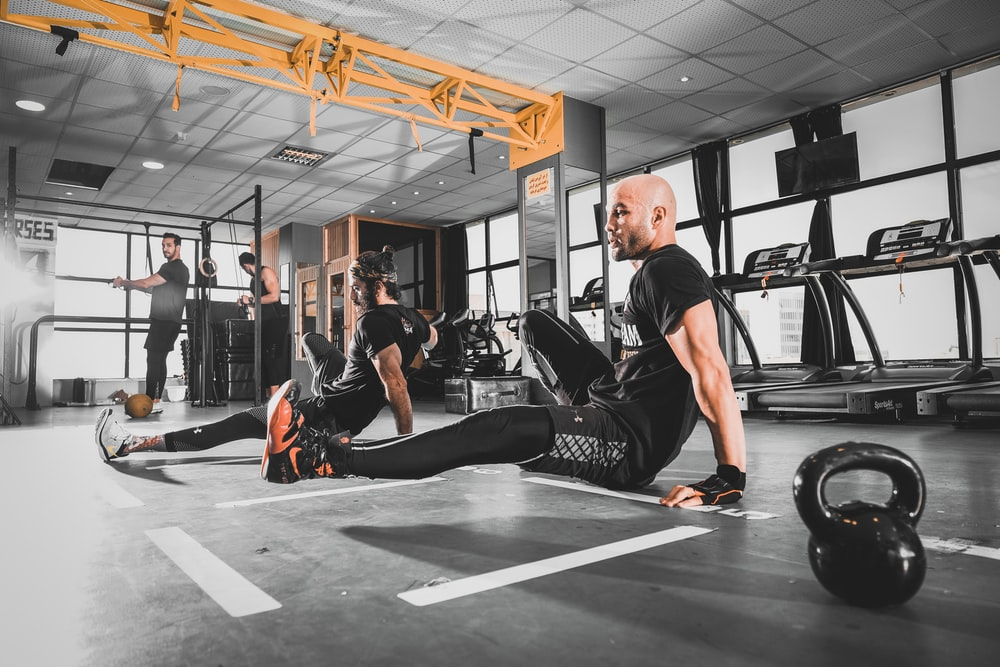 A man in a black top working out at the gym