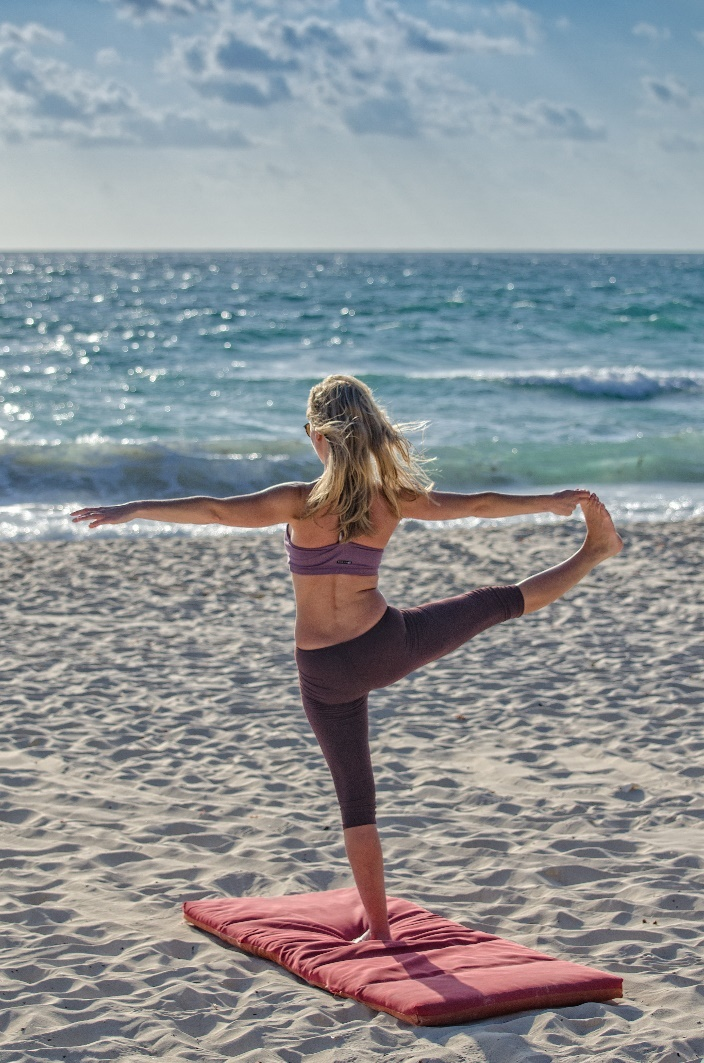 Woman doing yoga at the beach