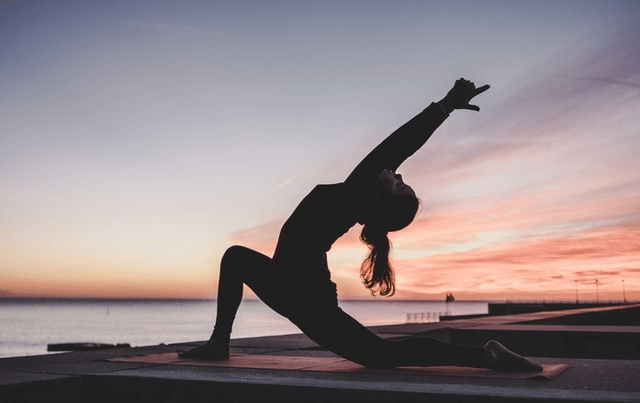  A woman doing yoga by the beach