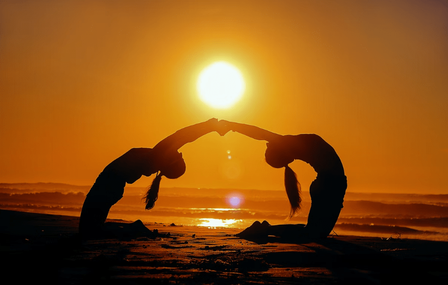 Partners doing yoga on the beach