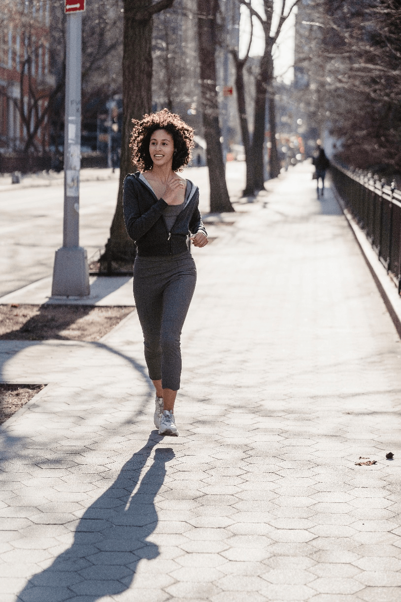 A woman jogging on a sidewalk