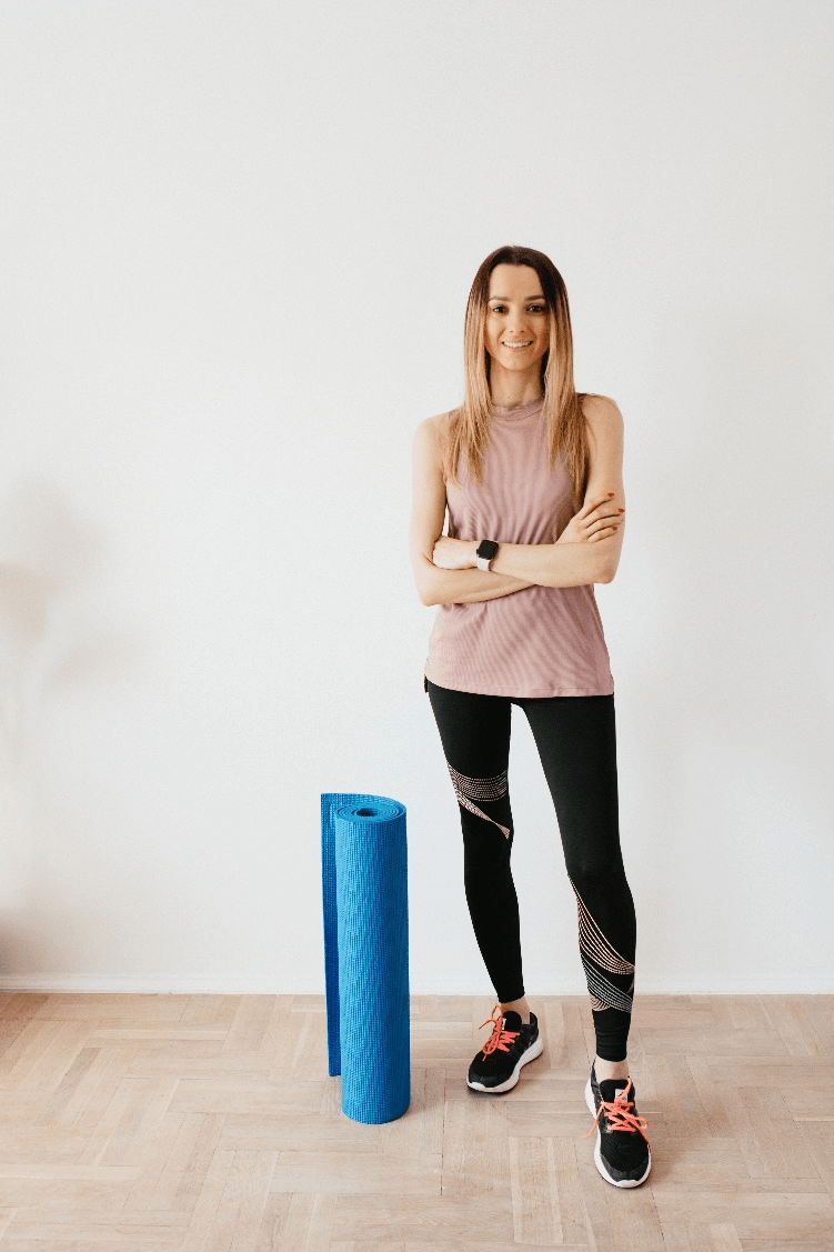 Woman standing next to a folded mat