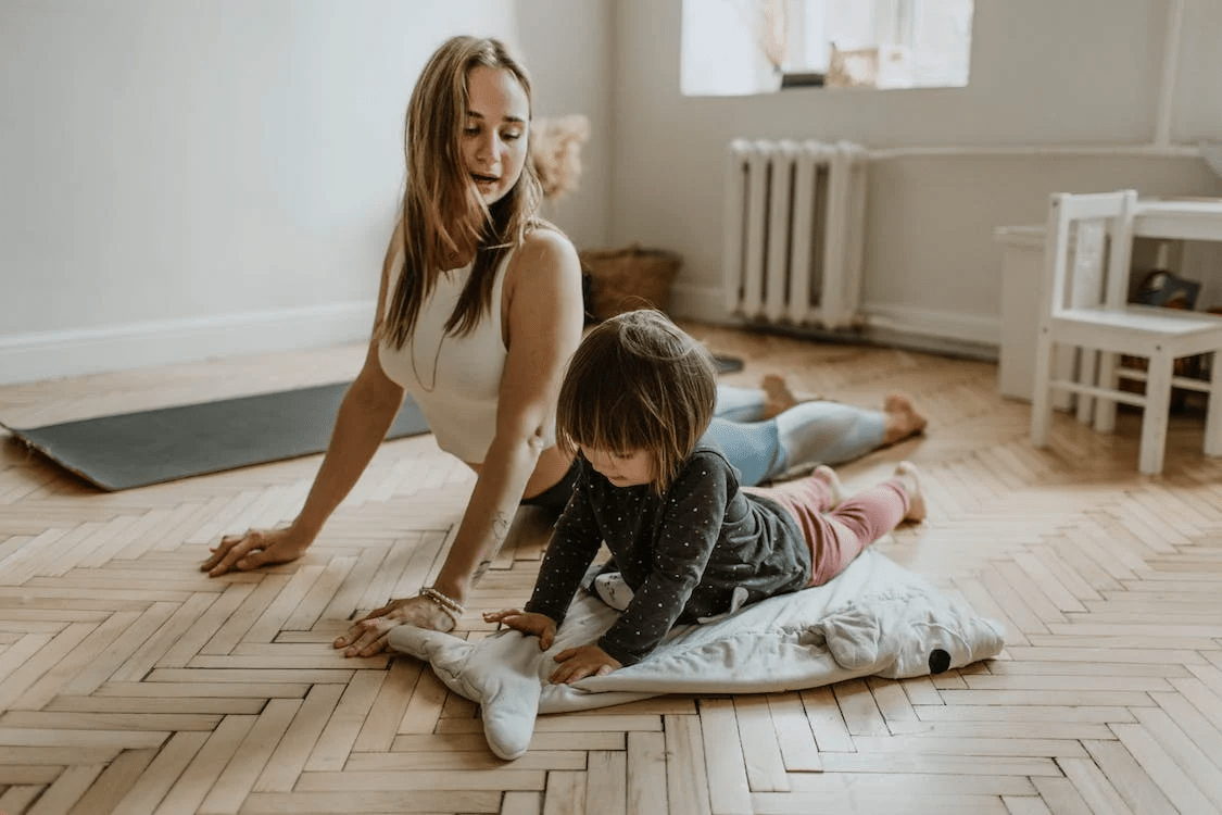 Text: A yogi with her child during a pose