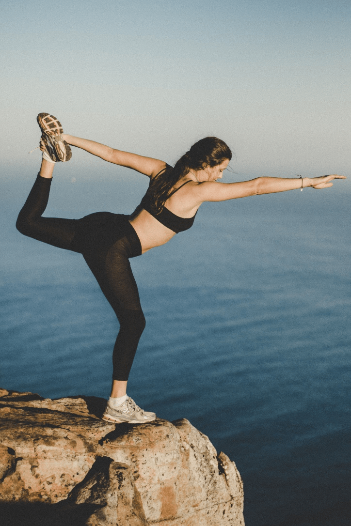 Woman doing yoga on a rock