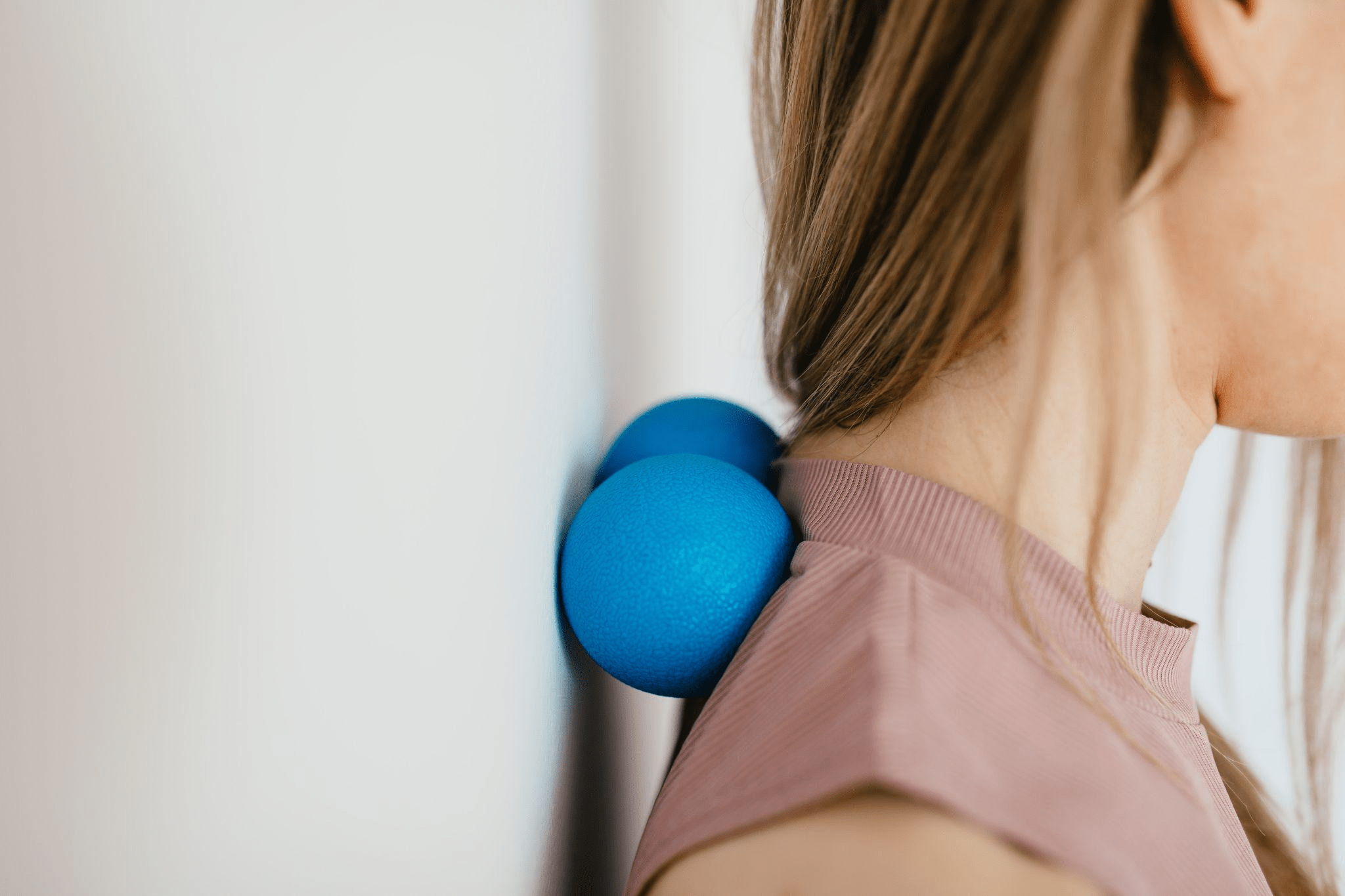 A woman using a stress ball on her neck