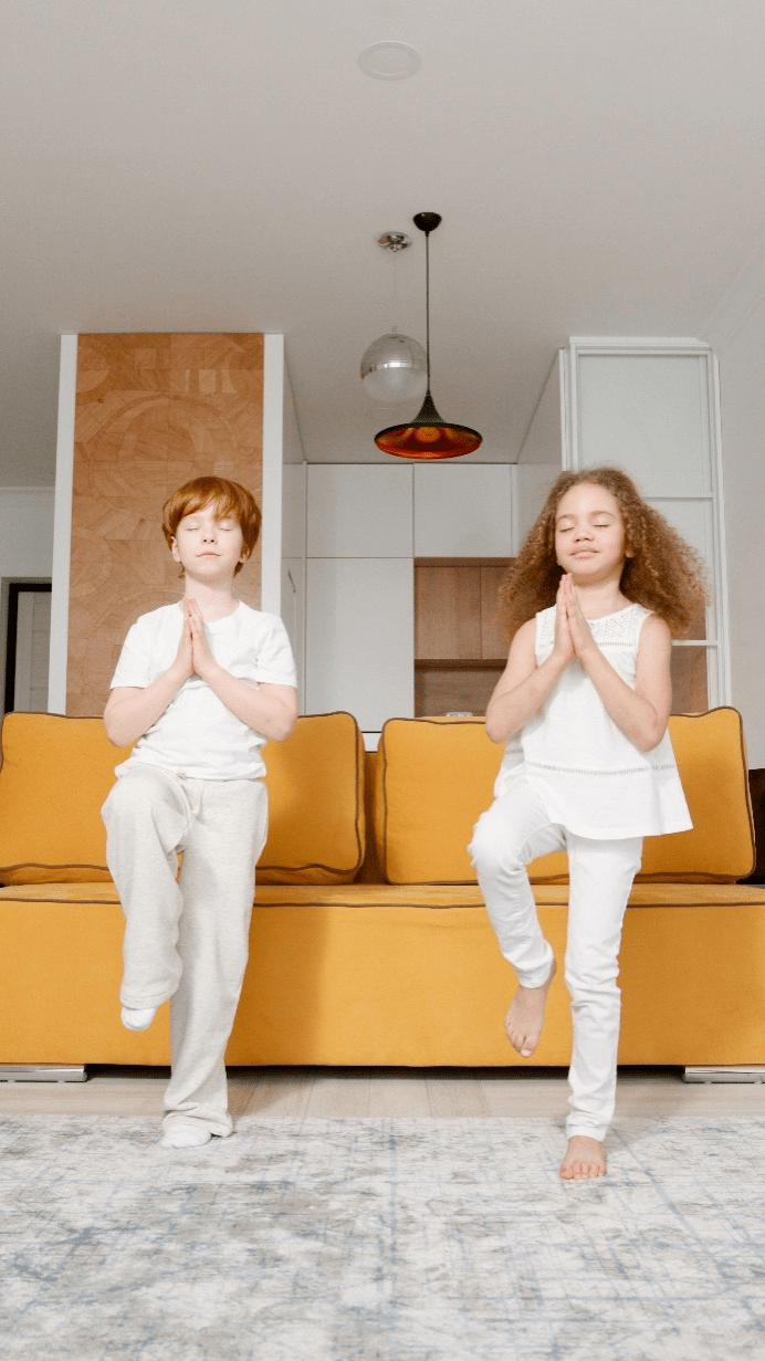 Two children practicing yoga at home