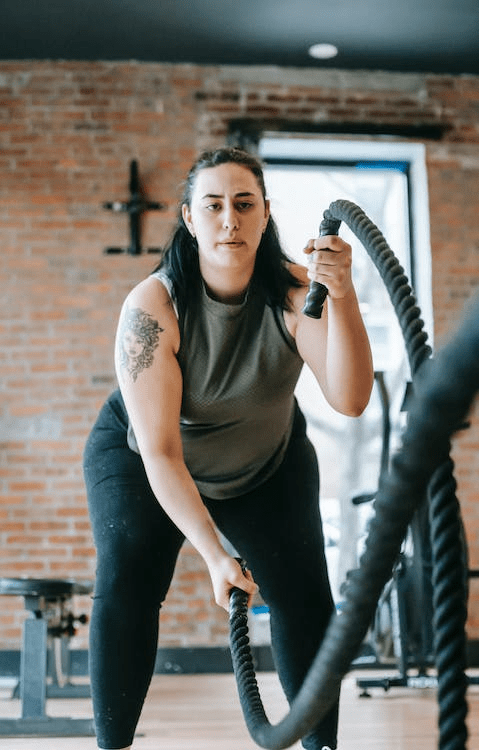 A woman exercising with battle ropes.